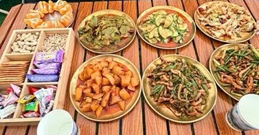 Plats sautés et en-cas servis sur une table en bois au camp de base du Siguniang.